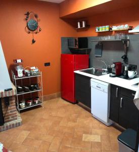 una cucina con frigorifero rosso e lavandino di La Casita de Pedraza a Segovia
