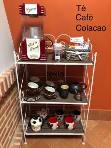 ein Regal mit Töpfen und Pfannen sowie einer Kaffeemaschine in der Unterkunft La Casita de Pedraza in Segovia