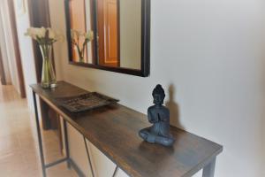 una statua seduta su un tavolo in una stanza con specchio di Piso Vacaciones en el mar a Sanxenxo