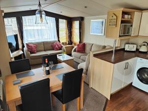 a kitchen and living room with a table and a caravan at Holiday home sleeps six in Poole