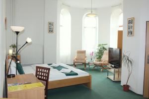 Cette chambre comprend un lit, une table et une télévision. dans l'établissement Hotel Central, à Český Těšín