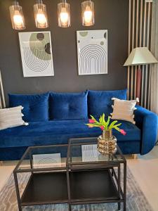 Sofá azul en la sala de estar con mesa de cristal en Apartament z garażem blisko dwóch jezior na Warmii i Mazurach, en Biskupiec