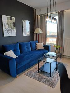 Sofá azul en la sala de estar con mesa en Apartament z garażem blisko dwóch jezior na Warmii i Mazurach en Biskupiec