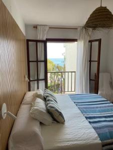 a bedroom with a large bed with a window at Casa frente al mar en Miami Playa 2hab in Miami Platja