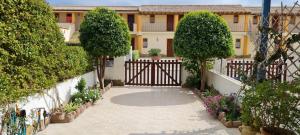 um portão para uma casa com árvores e flores em Sa Domu Tabarchina em Calasetta