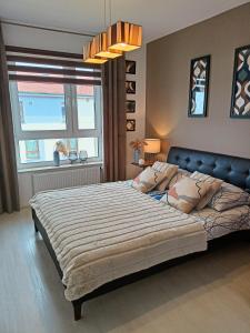 Un dormitorio con una cama grande y una ventana en Apartament z garażem blisko dwóch jezior na Warmii i Mazurach, en Biskupiec