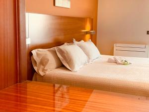 un dormitorio con una cama con un animal de peluche en Hostal Esperanza del Mar, en Portonovo