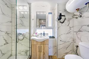 uma casa de banho com um lavatório e um chuveiro em Ionian Citizen Atelier em Corfu Town