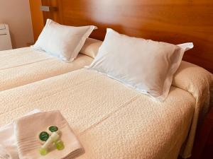 Una cama con una cruz y una toalla. en Hostal Esperanza del Mar, en Portonovo