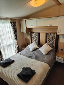 a bedroom with two beds with towels on it at Holiday home sleeps six in Poole