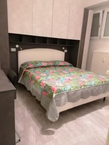 a bedroom with a bed with a floral comforter at Le 2M Apartment in Bologna