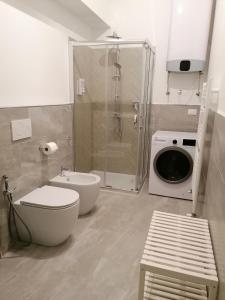 a bathroom with a shower and a toilet and a washing machine at Le 2M Apartment in Bologna