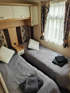 1 dormitorio pequeño con 2 camas en una caravana en Holiday home sleeps six, en Poole