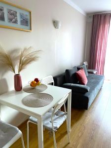 uma sala de estar com uma mesa branca e um sofá em Apartament Agaciula em Krynica Morska