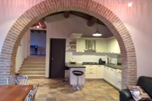 a kitchen with an archway in the middle of a room at Casa nella campagna Umbra in San Terenziano