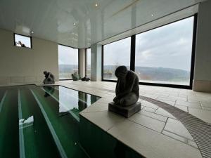 a museum with a statue in the middle of a pool at Sassor Village in Theux