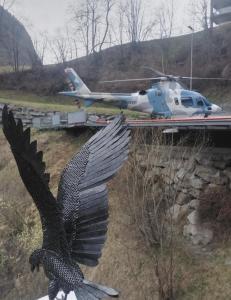 a statue of a bird with its wings out and a helicopter at BlackRock in Stalden