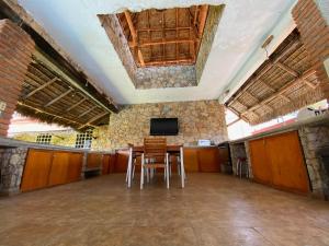 a large room with a table and a tv on a wall at Casa de Piedra. Tequesquitengo in Tequesquitengo