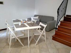 a white table and chairs in a living room with a couch at Casa Angelina in Grado
