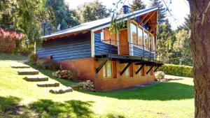 een huis met een balkon aan de zijkant bij Cabañas Carelmapu in Bariloche