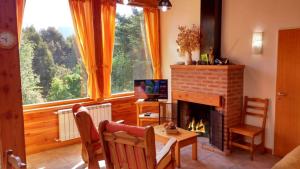 een woonkamer met een open haard en een televisie bij Cabañas Carelmapu in Bariloche