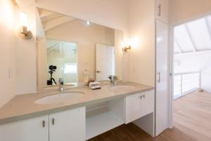 een badkamer met 2 wastafels en een grote spiegel bij Westmoreland Cottage in Saint James