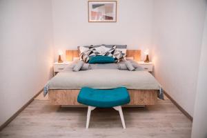 a bedroom with a bed and a blue chair at Guest House Mylan in Ličko Petrovo Selo