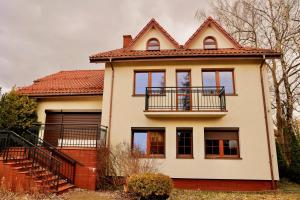 Biały dom z czerwonym dachem w obiekcie Villa Krasnowolska Airport - Self Check-in w Warszawie