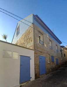 um edifício de tijolos com duas portas azuis em Casa O Castriño em Cambados