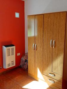 une pièce avec une grande armoire en bois et une télévision dans l'établissement Verde Silencio, à Tandil