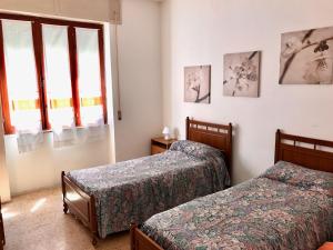 um quarto com 2 camas e uma janela em Casa in centro a due passi dal mare em Santa Teresa Gallura
