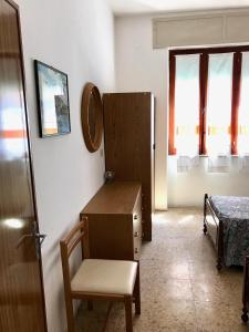 um quarto com uma cómoda, uma cadeira e uma cama em Casa in centro a due passi dal mare em Santa Teresa Gallura