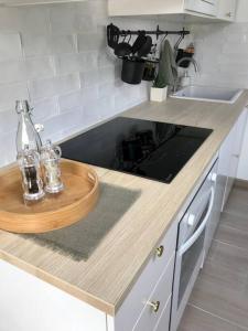 - un comptoir de cuisine avec un évier et un plateau en bois dans l'établissement - La Vie Douce - Entre Océan & Marais, à Saint-Michel-en-lʼHerm