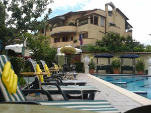 un grupo de sillas y mesas junto a la piscina en Hotel Flowers, en Montecatini Terme