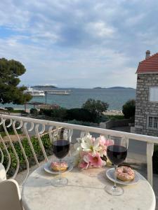 a table with two glasses of wine on a balcony at Apartment Seaside Orebić in Orebić