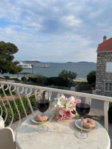 einen Tisch mit zwei Gläsern Wein auf dem Balkon in der Unterkunft Apartment Seaside Orebić in Orebić