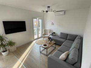 ein Wohnzimmer mit einem Sofa und einem Flachbild-TV in der Unterkunft Apartment Seaside Orebić in Orebić