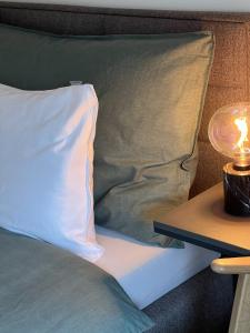 a bed with a pillow and a lamp on a table at Swiss Art Apartment City Center in Zurich