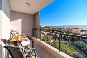 einen Balkon mit einem Tisch und Stühlen sowie Meerblick in der Unterkunft Golden view 7 in Split