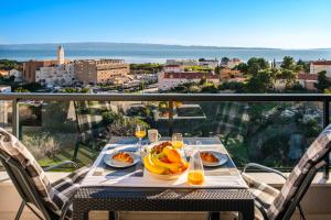 einen Tisch mit Obstteller und Weingläsern auf dem Balkon in der Unterkunft Golden view 7 in Split