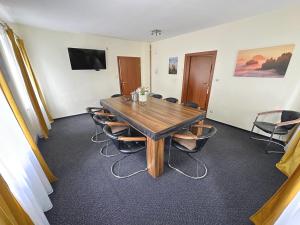 une salle de conférence avec une table et des chaises en bois dans l'établissement Vila Vlčí Hora, à Krásná Lípa