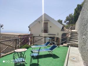 una casa con patio arredato con sedie e tavolo di Il piccolo Sogno in costiera Amalfitana a Conca dei Marini