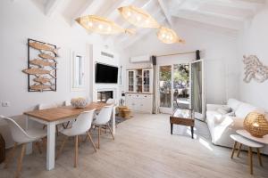 sala de estar con mesa, sillas y sofá en Olivea Premium Holiday Homes en Stavros