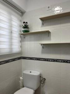 baño blanco con aseo y ventana en LA DESCALZA en Lucena