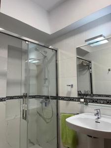y baño con ducha acristalada y lavamanos. en LA DESCALZA en Lucena