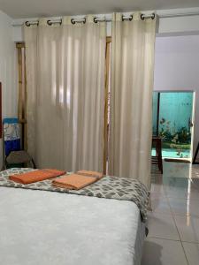 a bedroom with a bed with orange towels on it at Loft Ostara in Alto Paraíso de Goiás