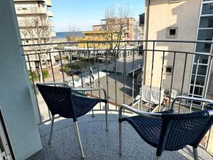 two chairs on a balcony with a view of a street at Hotel Blue Moon in Rimini