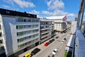 a city street with cars parked in front of buildings at Scandinavian 2-rooms apartment City Center in Helsinki