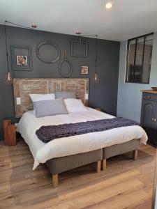 1 dormitorio con 1 cama grande y paredes azules en La Ferme Parrinet - Gîte et Chambres d'hôtes, en Saint-Martin-Laguépie