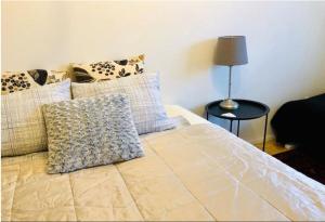 a bedroom with a bed with pillows and a lamp at Scandinavian 2-rooms apartment City Center in Helsinki